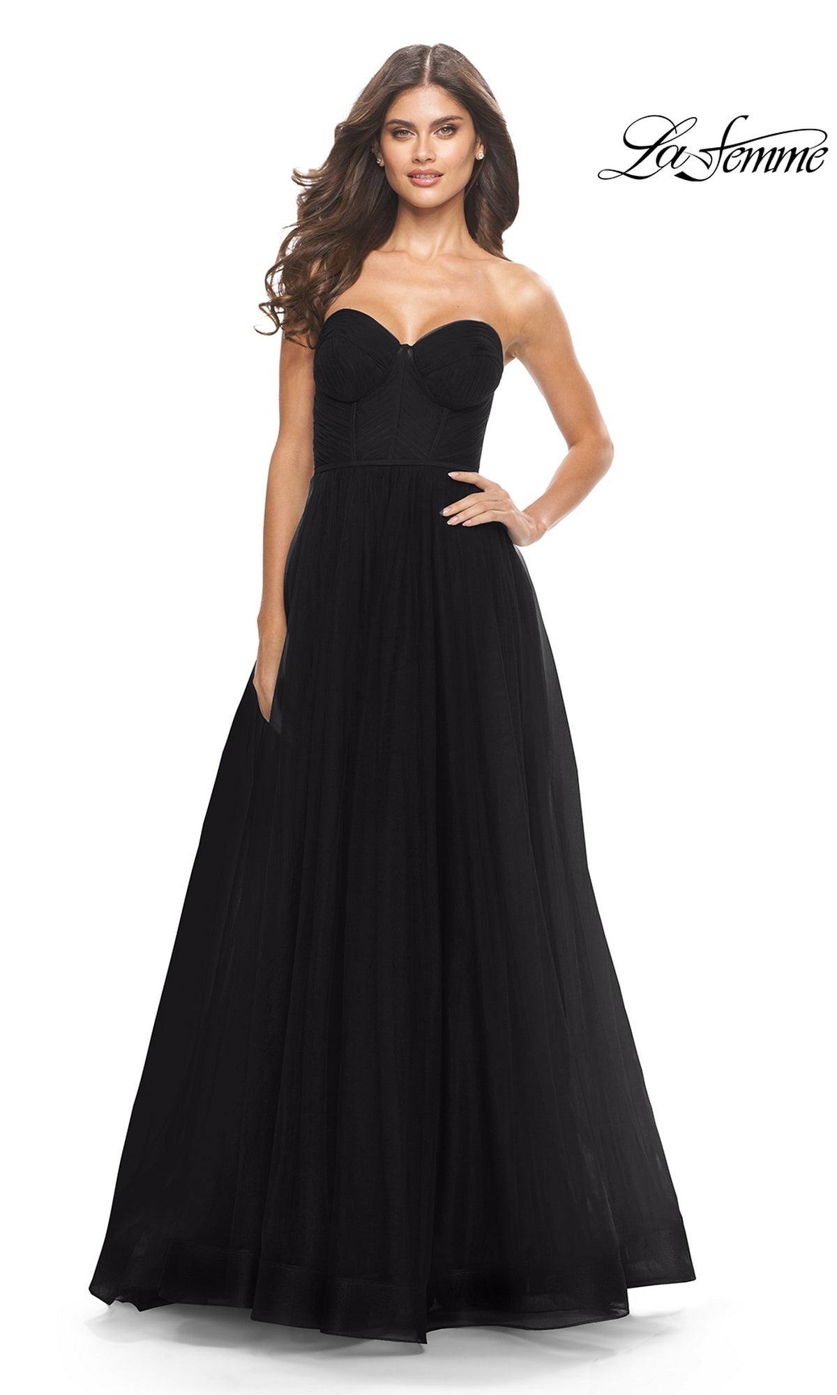 Woman in the Strapless Long Prom Ball Gown: La Femme 31205, featuring a fitted bodice and full A-line skirt, poses against a white background.